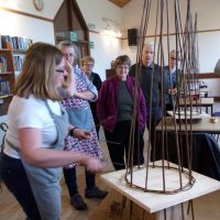 The hall is used for a variety of craft classes. A demonstration of wicker weaving at a class in the village hall.